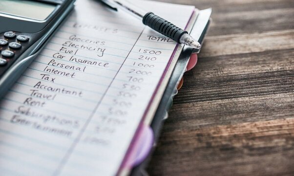 Shot of a notebook with a budget written on it showing how to save money fast.