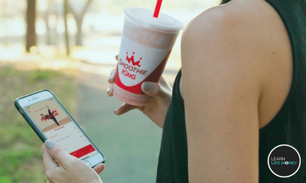 A woman drinking a smoothie from smoothie king.
