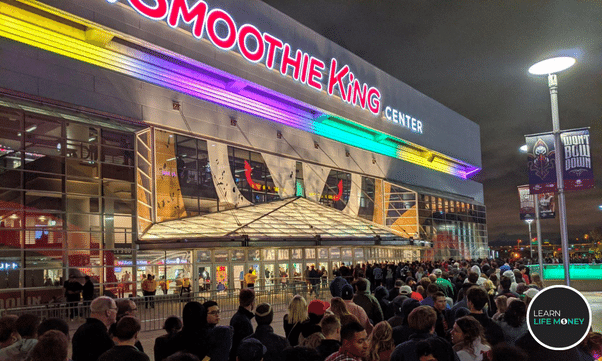 A smoothie king store with lots of customers outside.