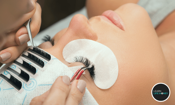 A woman putting eyelash extensions to her customer.
